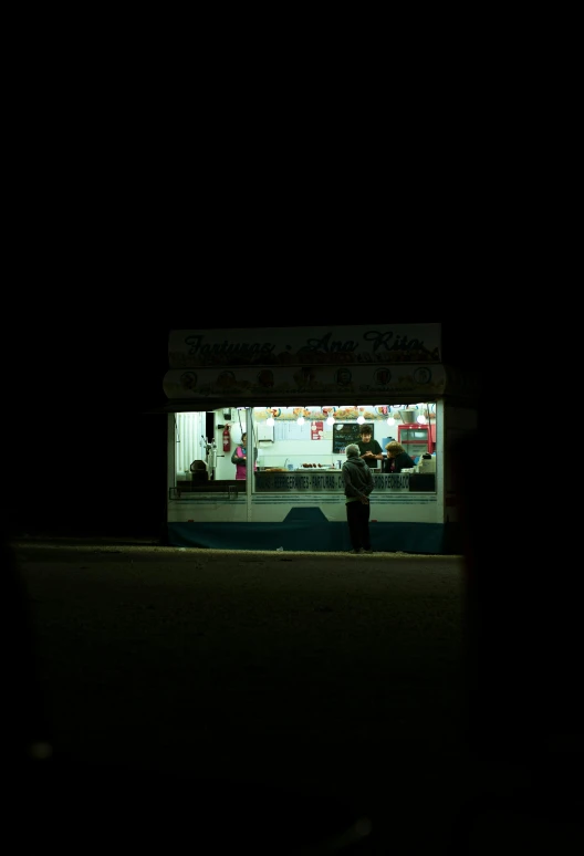 two people stand in the dark on a street corner