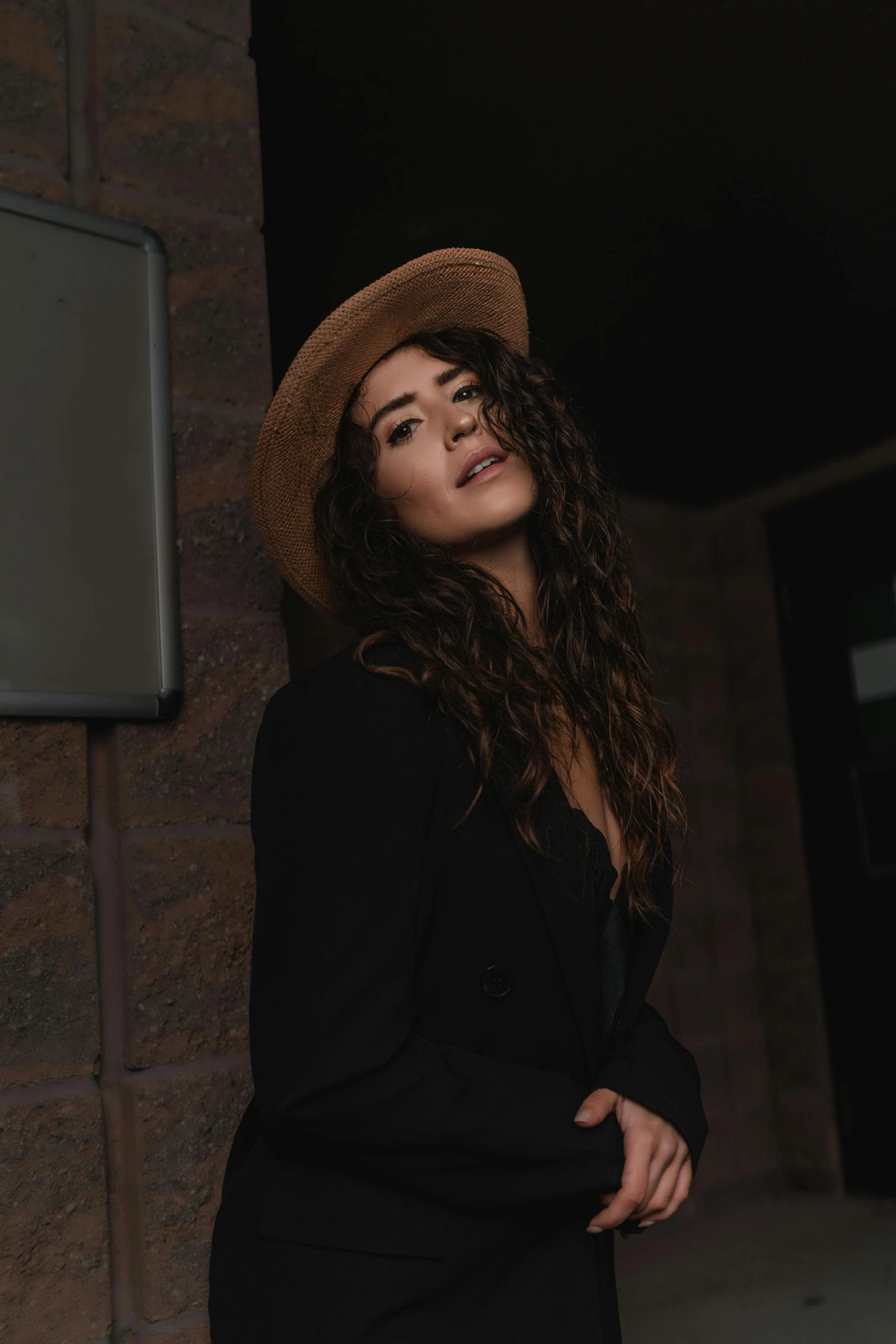 a woman standing in front of a building with a hat on