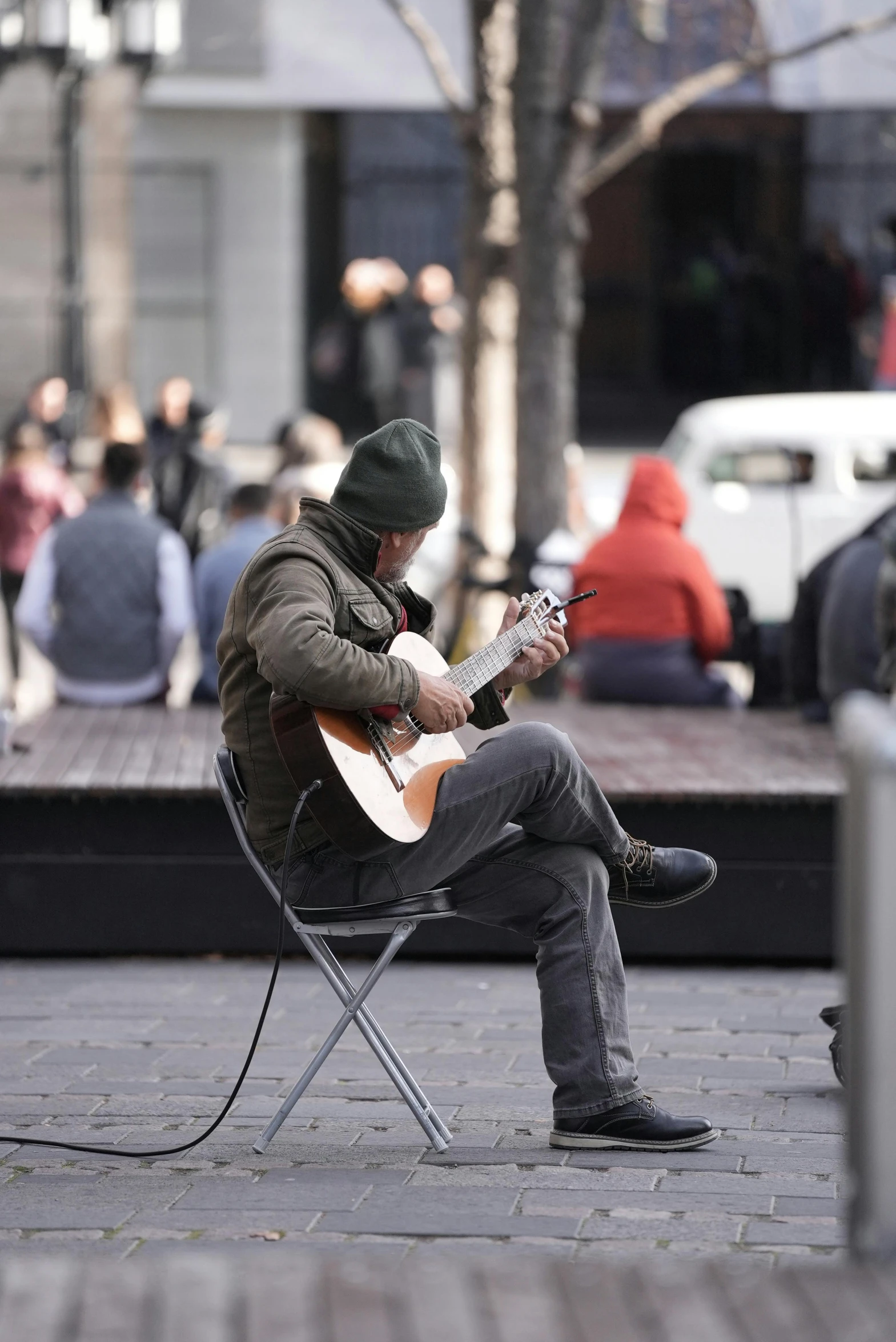 a man playing guitar on a street in the city