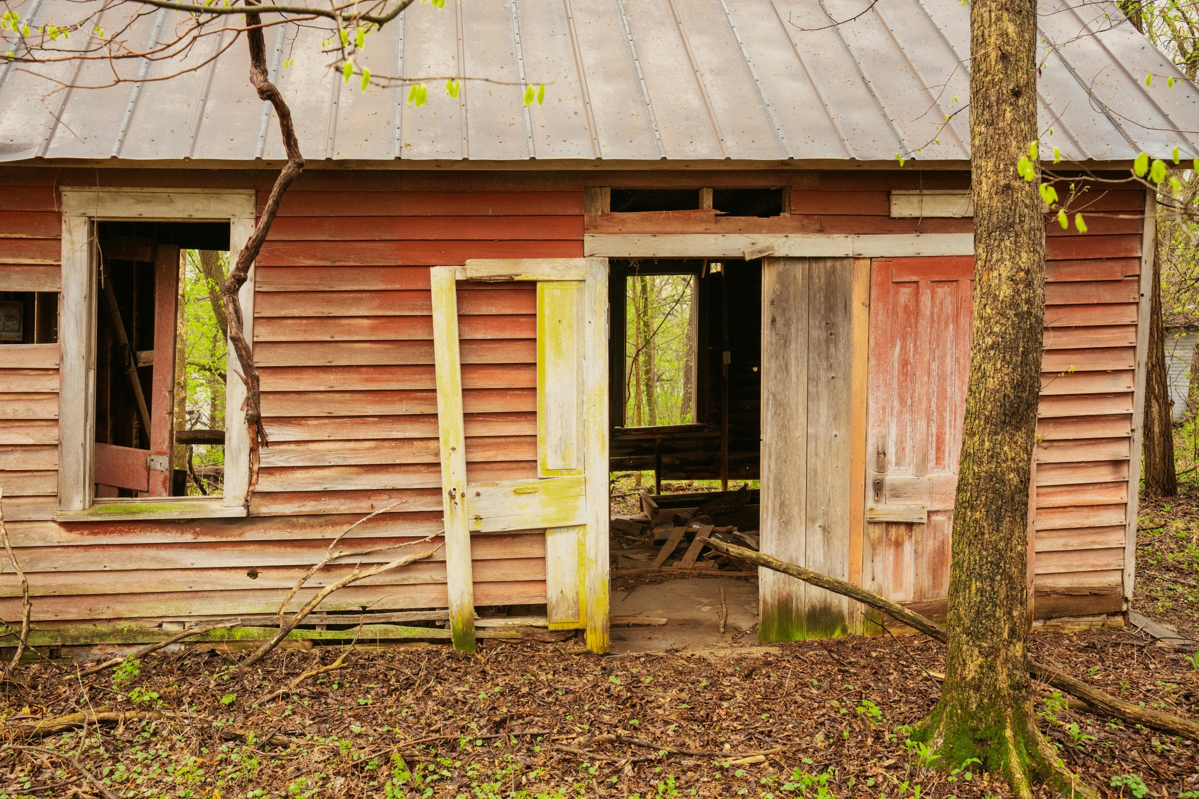 an old rundown, rusty building with a broken door