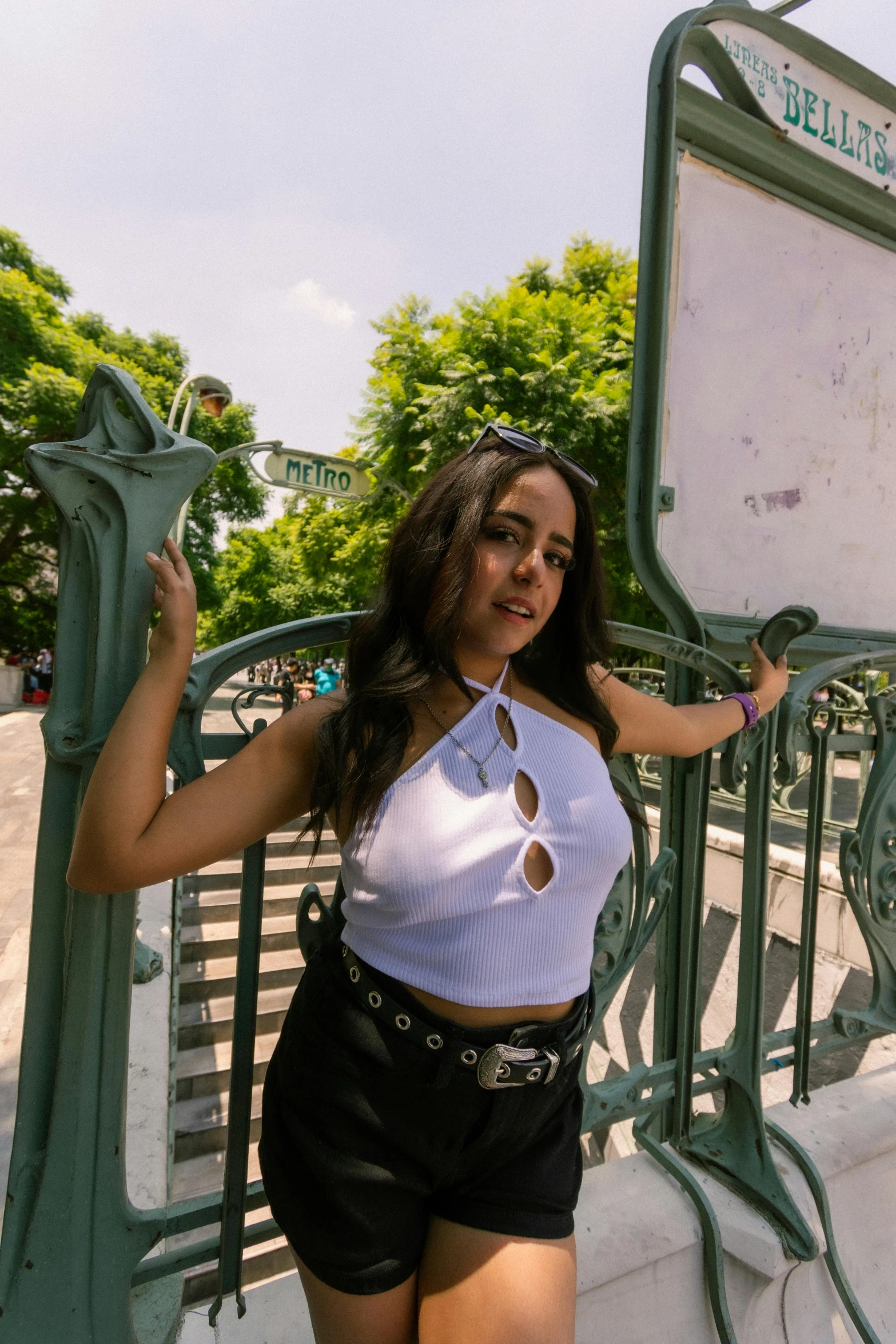 a pretty young lady standing near an iron gate