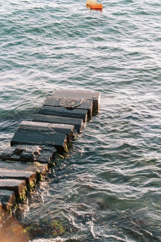 a stone pier stretches out into the ocean