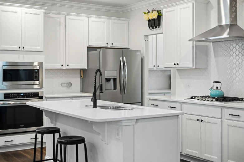 an all white kitchen with white cabinets and a stainless steel stove and refrigerator