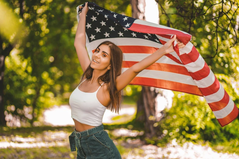 a girl holds an american flag up in the air