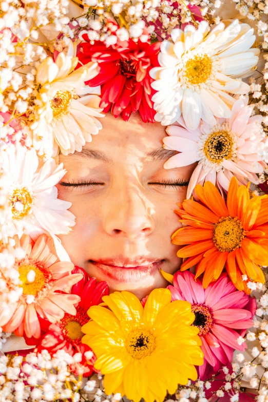 a child with her eyes closed while surrounded by flowers