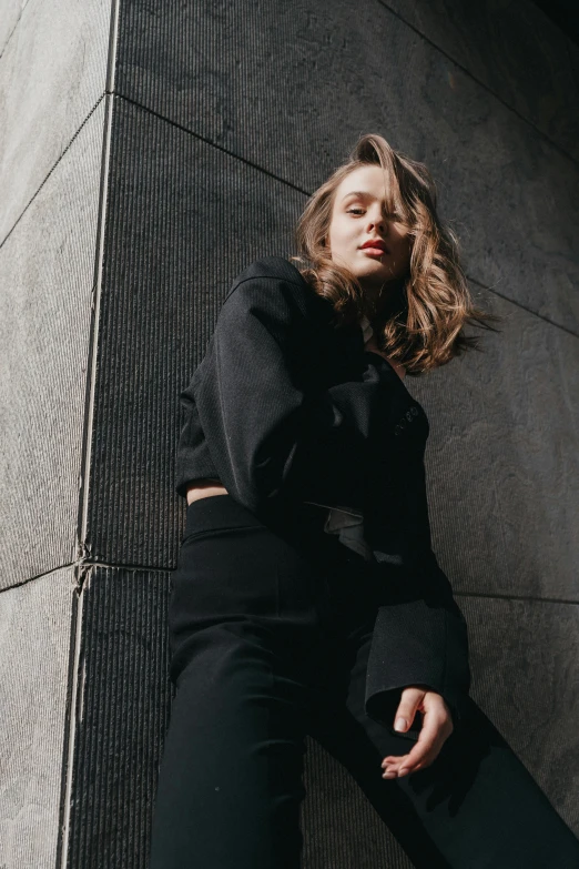 the young woman is leaning on the wall in front of her