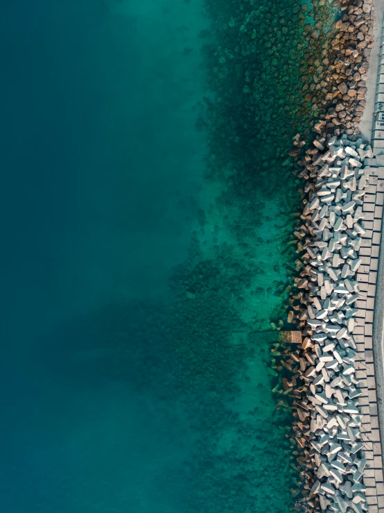 a beach with boats sitting at it's edge and people standing in the water