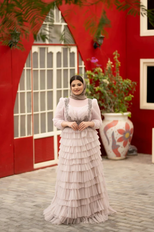 a woman stands on a brick path in a dress