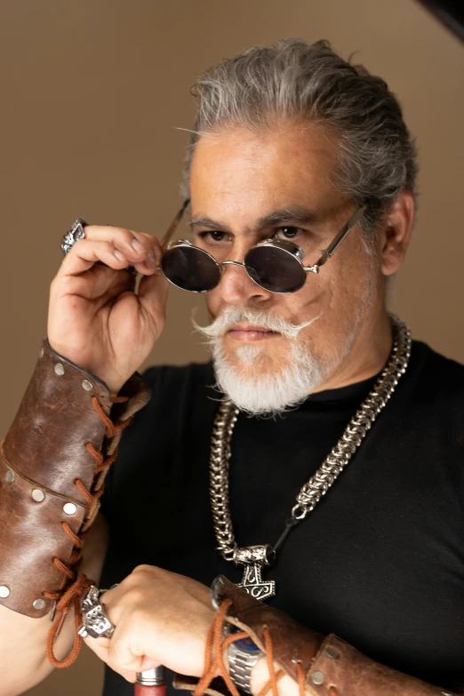 an older man wearing sunglasses and leather sleeves