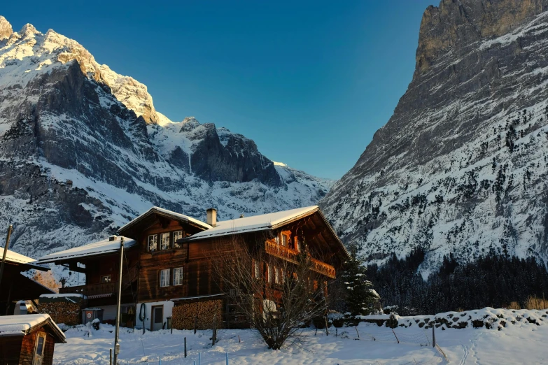 a wooden cabin surrounded by snow - capped mountains