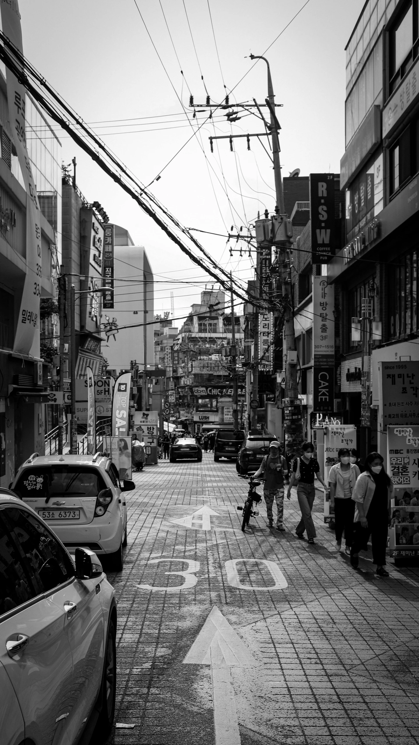 a black and white po of people walking down a sidewalk