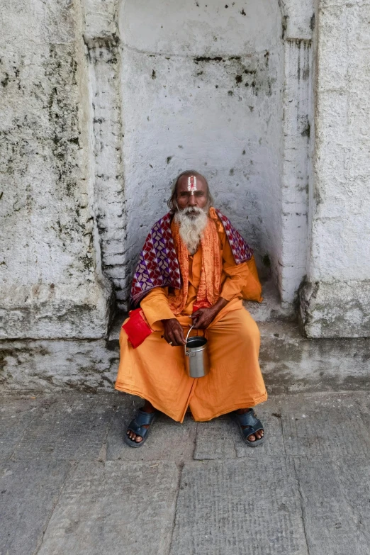 an indian man sits on the side of a building