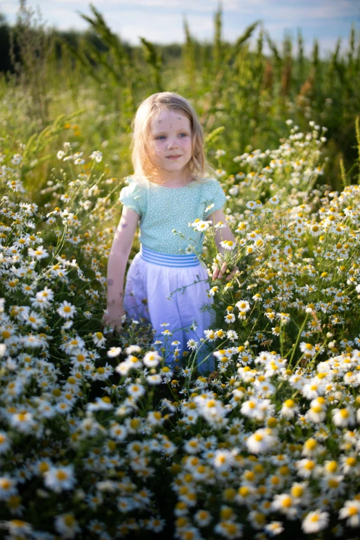 the girl is walking in some wildflowers near tall grass