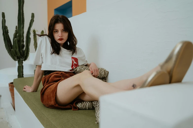 woman sitting on a ledge near cactus with high heels