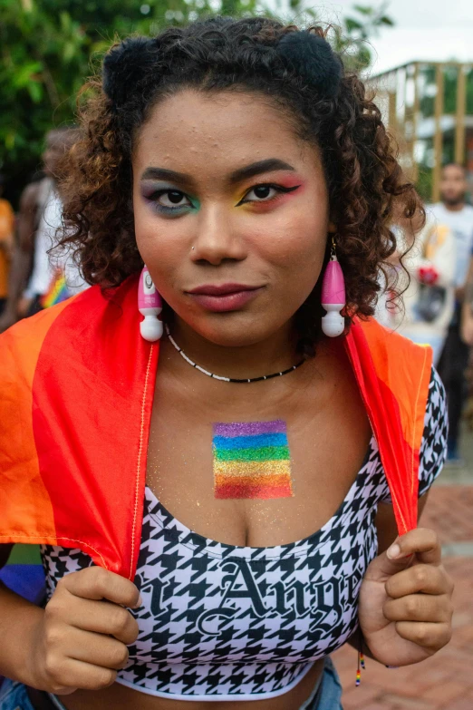 a girl wearing an over - sized shirt, holding a rainbow flag