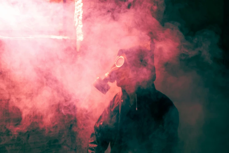 a person wearing a gas mask in a smoke filled area