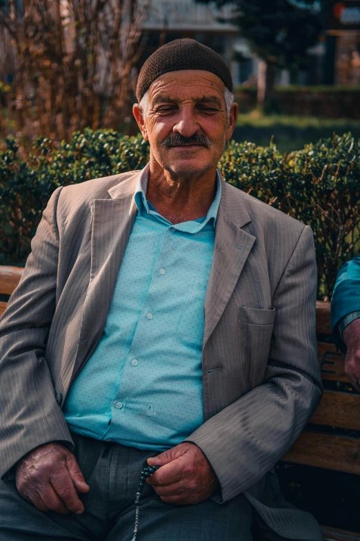 an old man is sitting down on a wooden bench