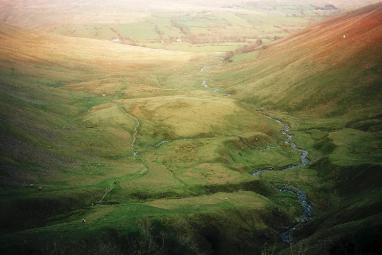 a hilly valley filled with green grass covered hills