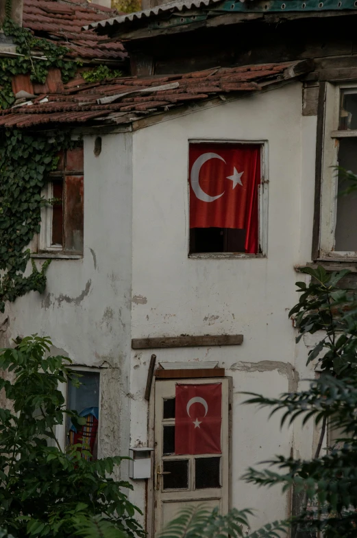 a red turkey flag hanging out of the windows of a white building