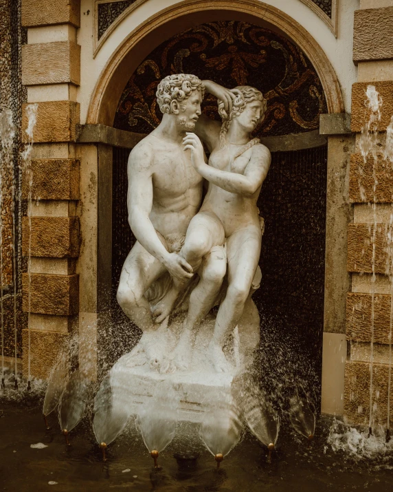 a fountain with statues of men surrounded by water