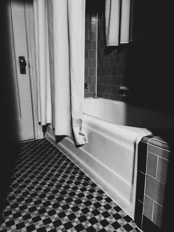 a black and white picture of a tiled bathroom