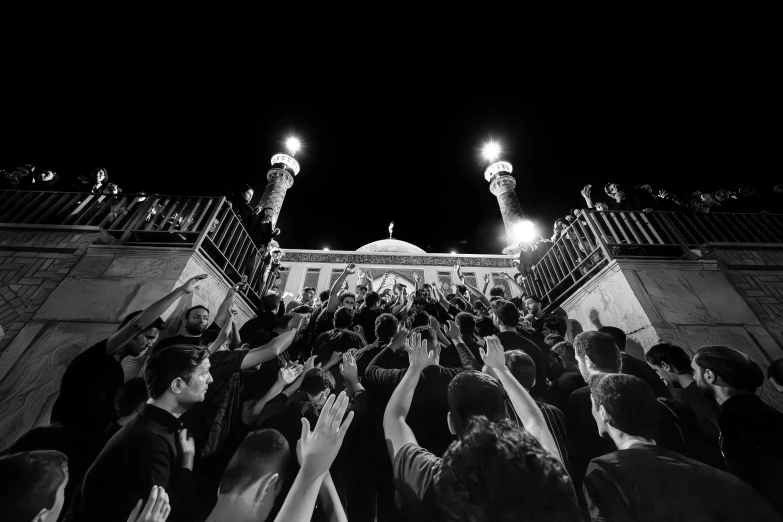 people holding up their hands outside of a building