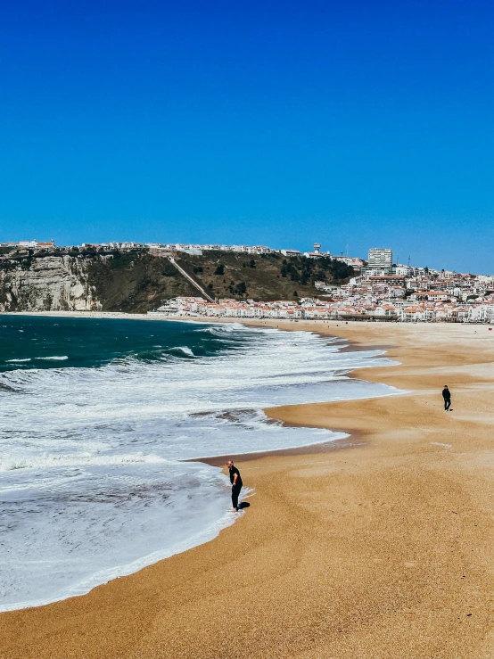 there are two people walking on the beach together