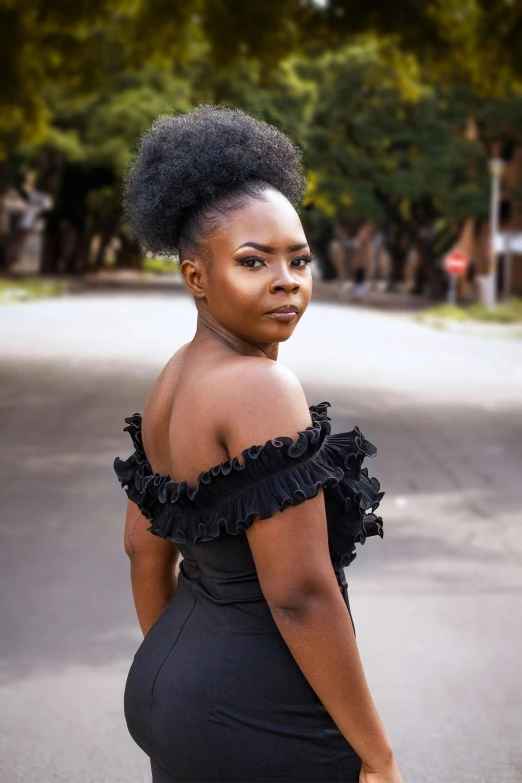 woman in black off shoulder top posing on street