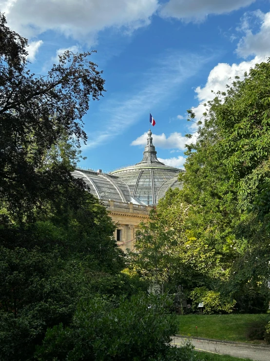 this is a beautiful building in the distance surrounded by trees and greenery