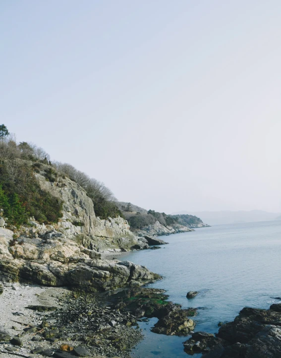 there is water near the rocky shoreline on a clear day