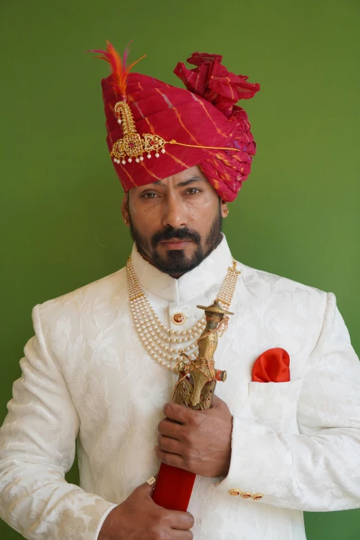 an indian man in a turban holding a sword