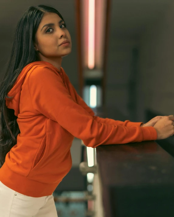 a woman in a very  orange sweater posing for the camera