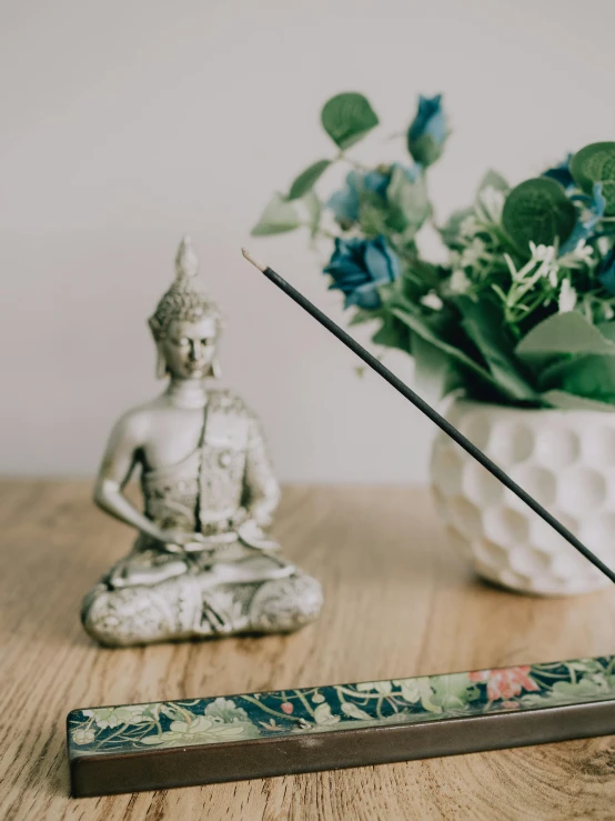 a statue sits next to an incense stick