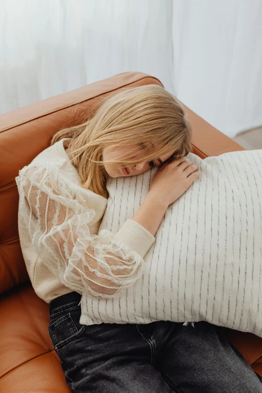 a woman sleeping with her arm on the back of a couch