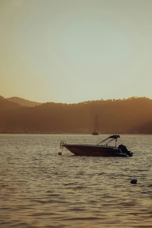 a boat on a large body of water with mountains in the background