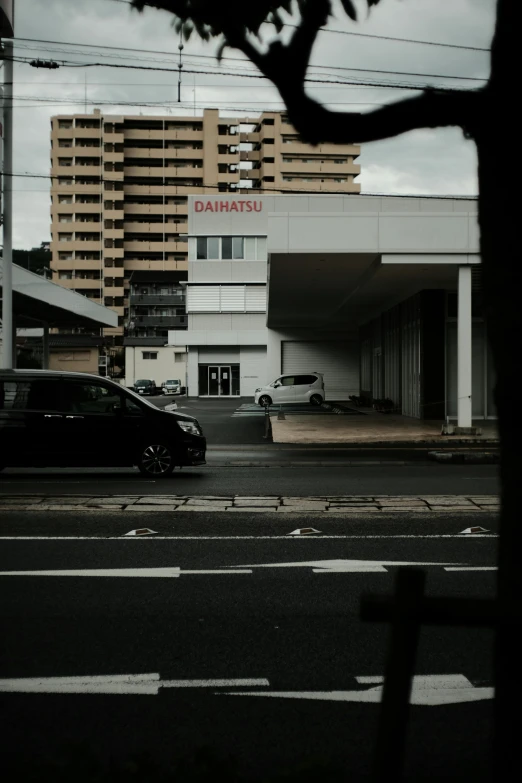 a black car traveling down a street near tall buildings