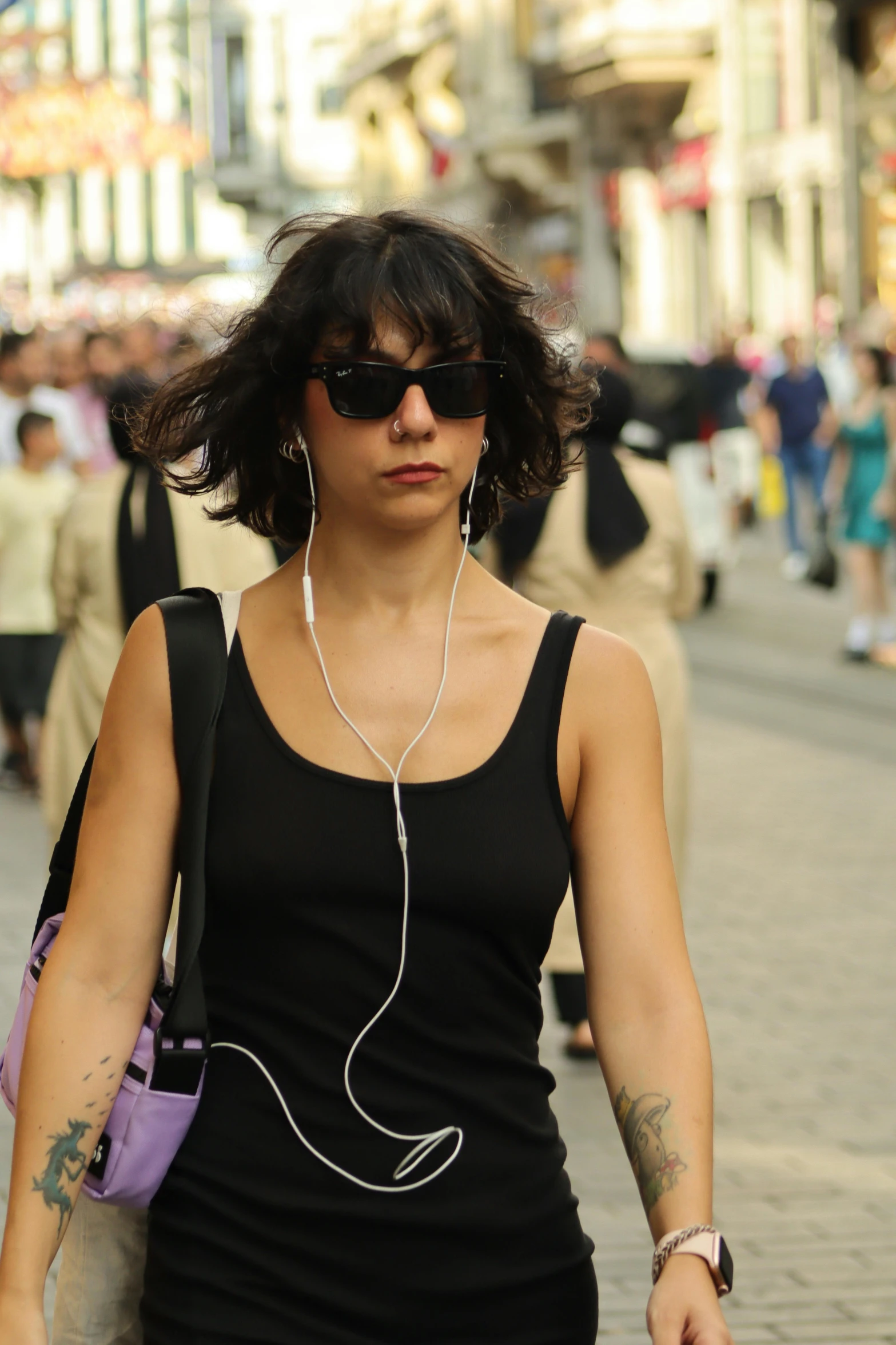 a woman with ear buds is walking down the street