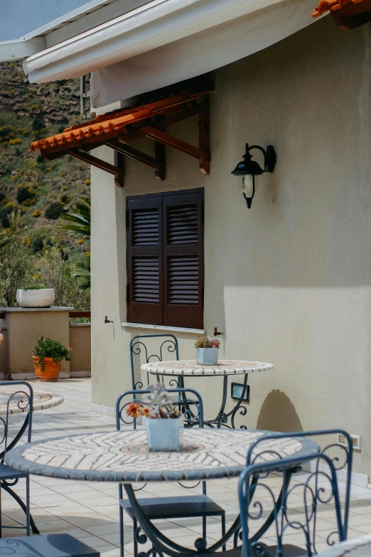 a table set up outside a house with an iron frame