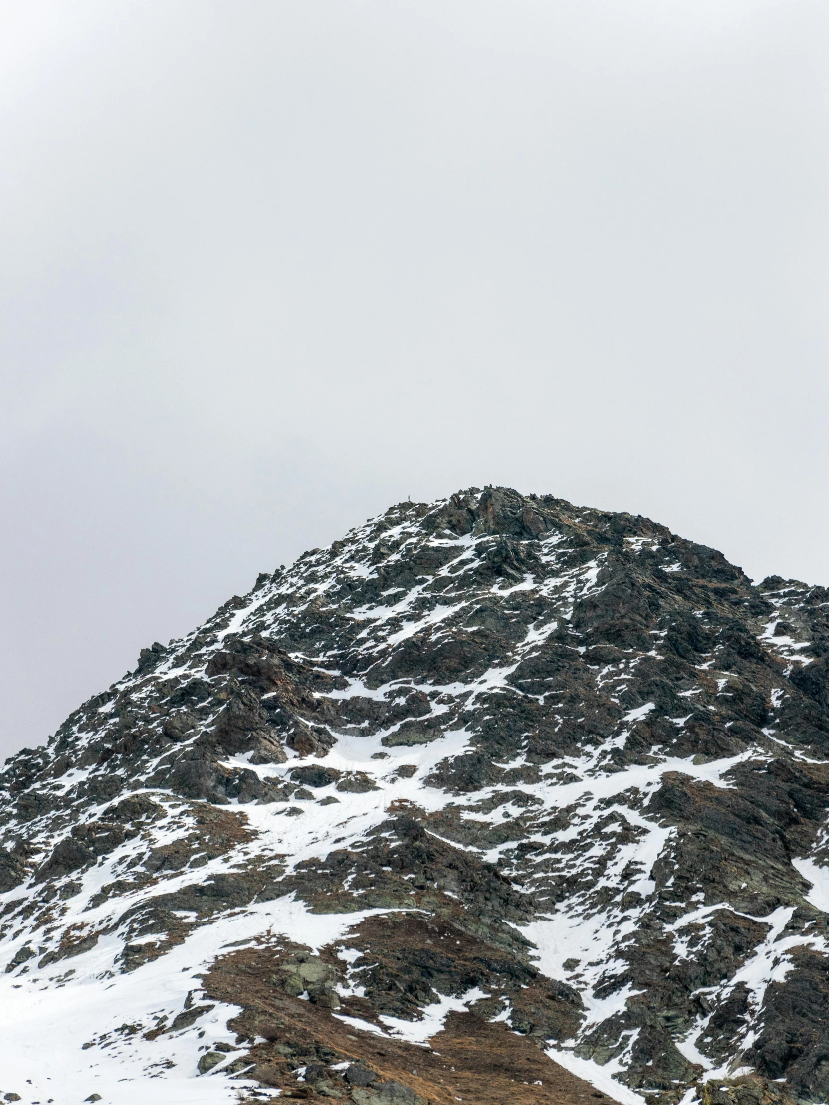 a snowy mountain covered in thick layering with a small house below