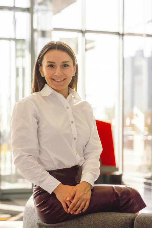 a woman in white shirt and brown pants posing for a picture