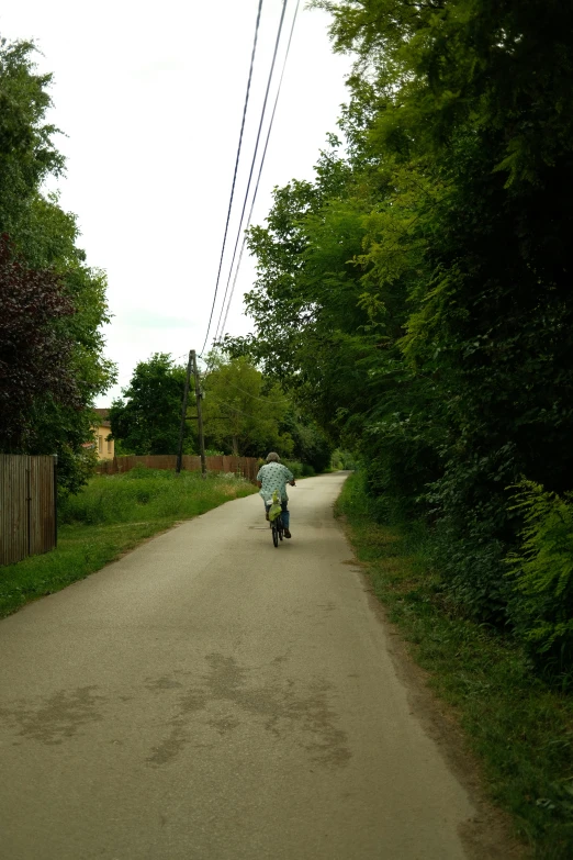 a person riding a bike down the middle of a road