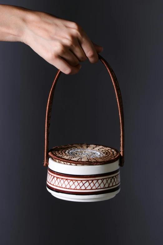 hand holding basket decorated with intricate decorative motif