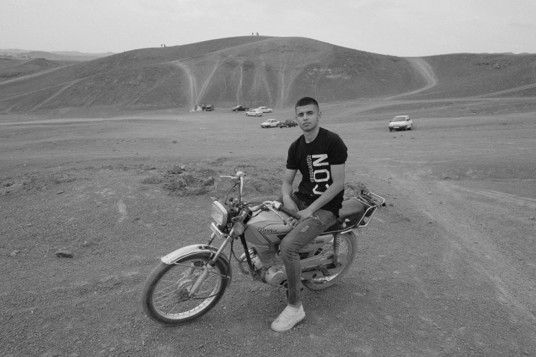 a man sits on a bike near an open parking lot