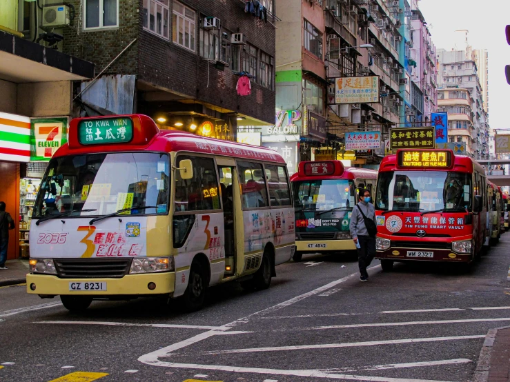 several buses driving on the city street