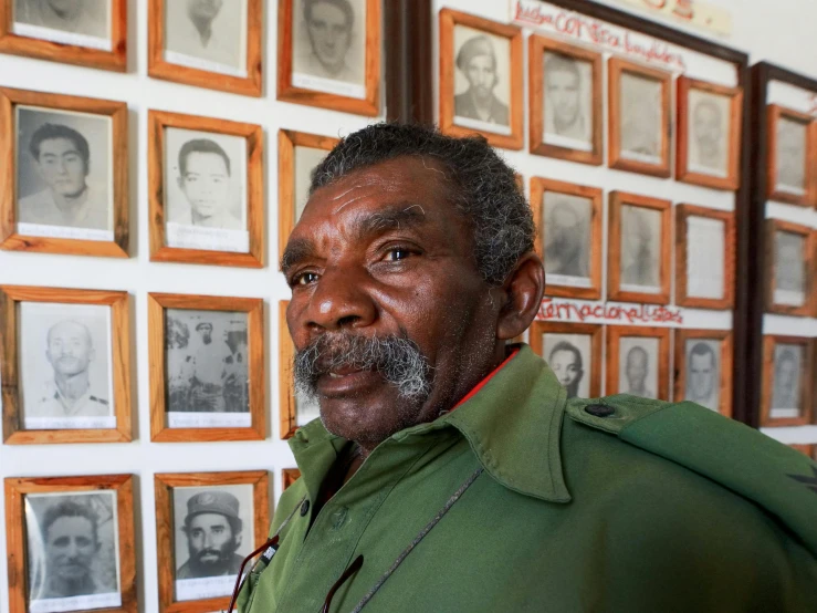 an old man is posing in front of portraits