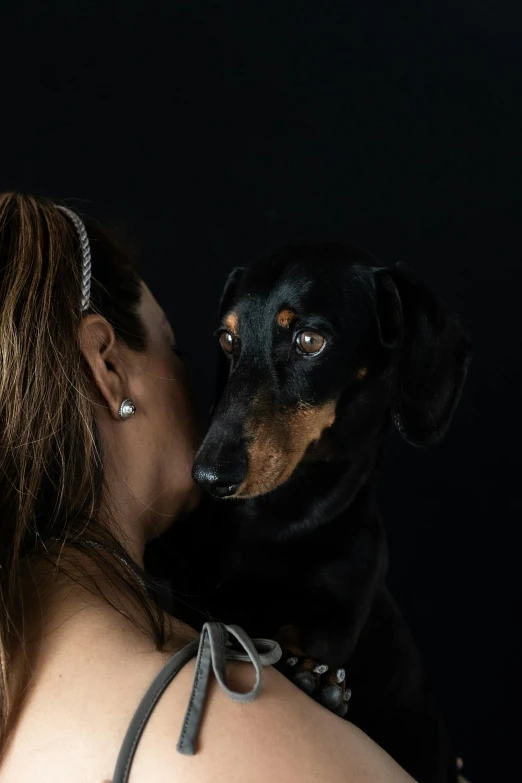 a woman kissing a dog with her eyes closed