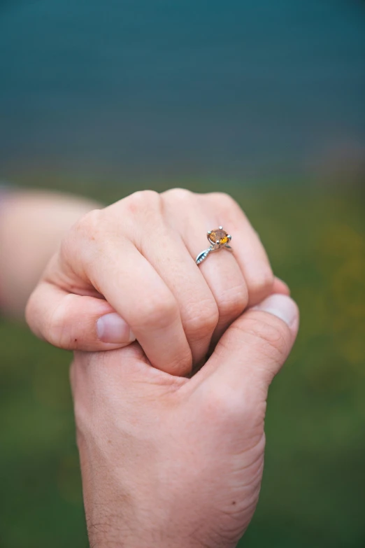 the woman is holding the ring on her finger