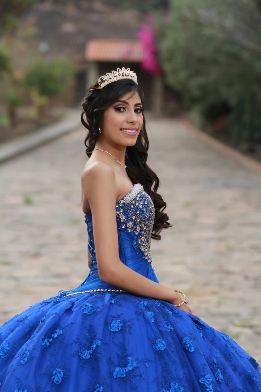 a beautiful young woman in a blue gown with a tiara