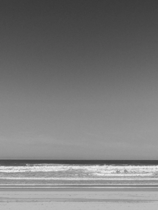 a person is holding a surf board on a beach