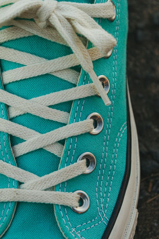 a blue tennis shoe with white laces tied around it